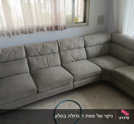 ספה אפורה עם כתמים קלים בחדר מגורים
